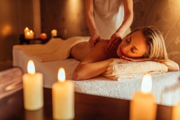 Escena de un masaje relajante antiestrés: una persona recibiendo un tratamiento que reduce la tensión muscular, mejora la circulación y fomenta la conexión mente-cuerpo en un ambiente sereno.
